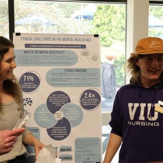 Students presenting an infographic poster at CREATE conference