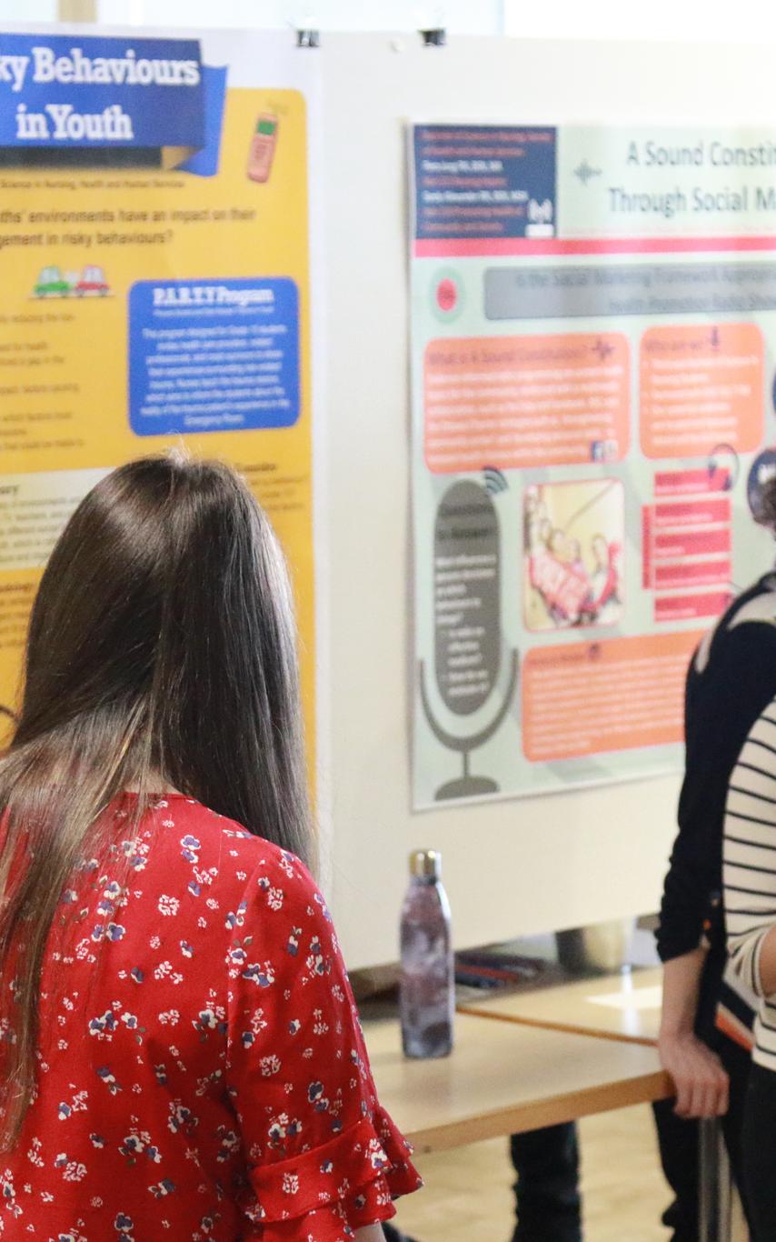 Students talking at CREATE with posters in background